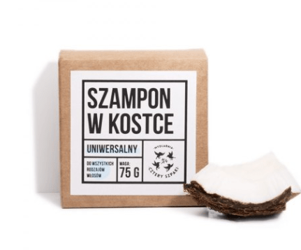 Shampoo bar from Cztery Szpaki in paper square  box and a sliced coconut.