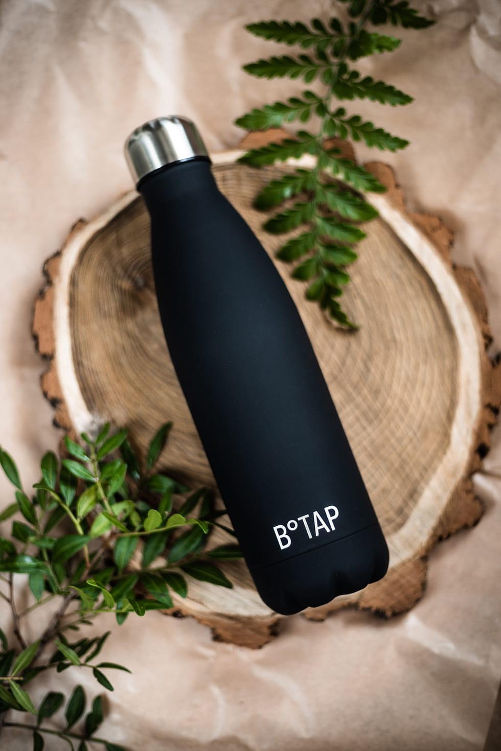 Botap thermos bottle on a wooden slice.